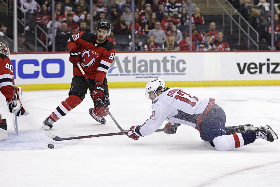 Washington Capitals center Dylan Strome, right, scores a goal past New Jersey Devils goaltender Akira Schmid (40) and defenseman Kevin Bahl (88) during the first period of an NHL hockey game Wednesday, Oct. 25, 2023, in Newark, N.J. (AP Photo/Adam Hunger)