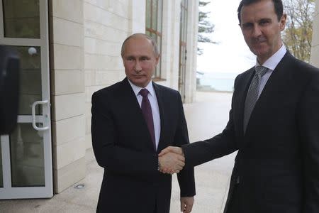 Russian President Vladimir Putin (L) shakes hands with Syrian President Bashar al-Assad during a meeting in the Black Sea resort of Sochi, Russia November 20, 2017. Picture taken November 20, 2017. Sputnik/Mikhail Klimentyev/Kremlin via REUTERS ATTENTION EDITORS - THIS IMAGE WAS PROVIDED BY A THIRD PARTY.