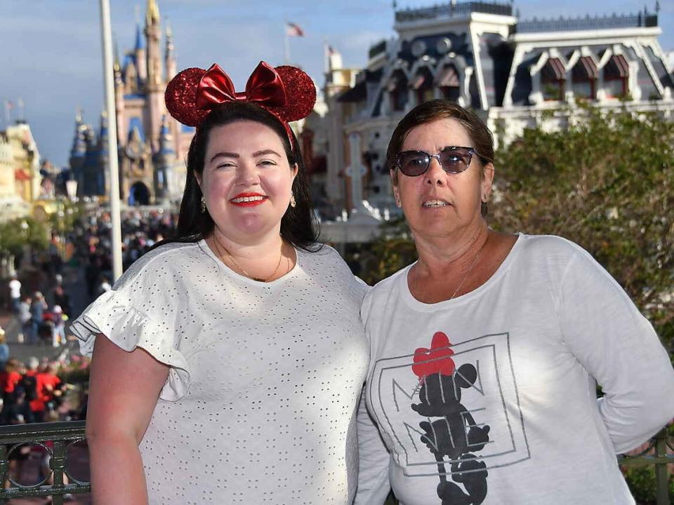 megan and her mom posing for a photo with cinderella castle in the background at magic kingdom