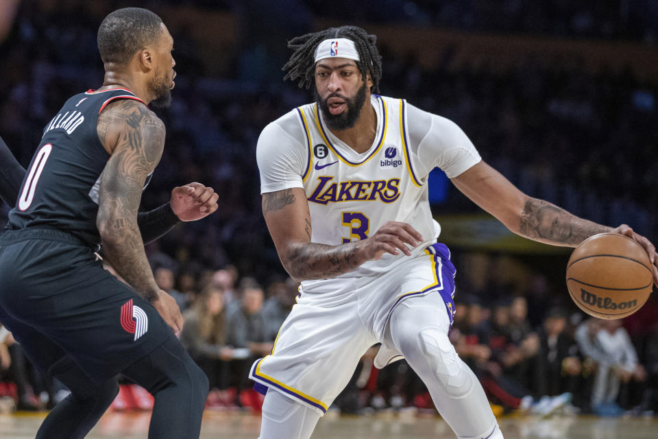 Los Angeles Lakers forward Anthony Davis, right, dribbles against Portland Trail Blazers guard Damian Lillard during the first half of an NBA basketball game Sunday, Oct. 23, 2022, in Los Angeles. (AP Photo/Alex Gallardo)