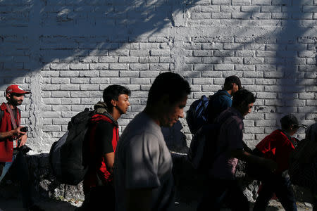 People walk in a caravan of migrants departing from El Salvador en route to the United States, in San Salvador, El Salvador, November 18, 2018. REUTERS/Jose Cabezas