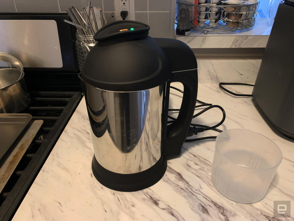 The Almond Cow plant milk maker assembled on a marbled countertop.