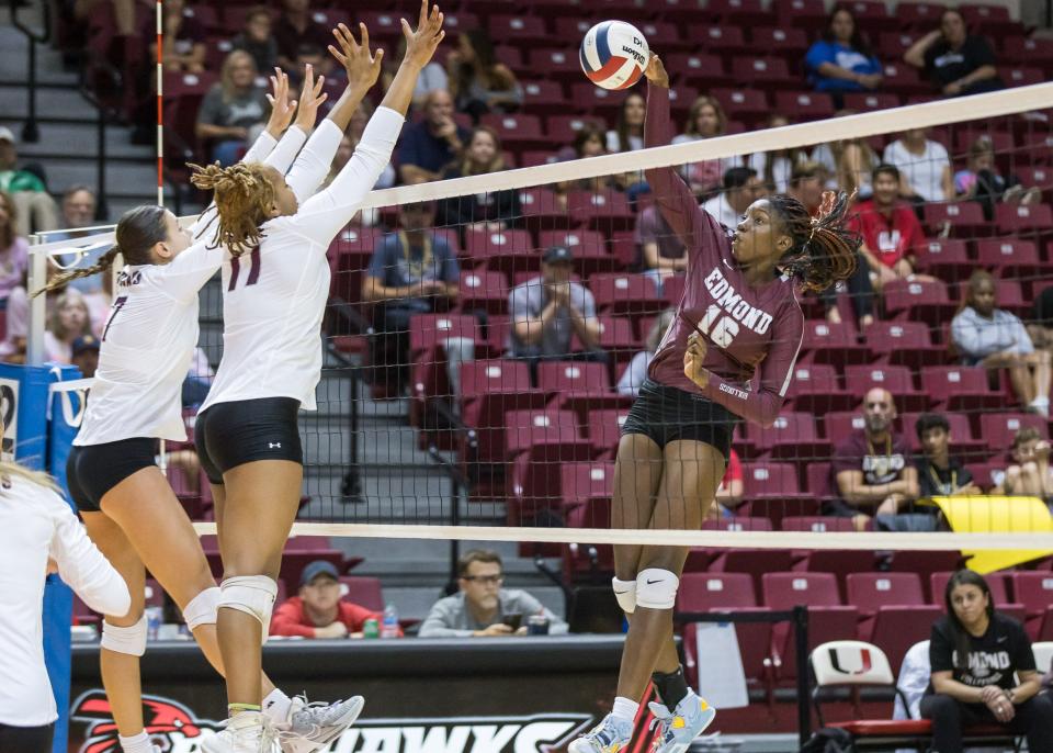 Edmond Memorial's Lolufe Adedeji (right) spikes the ball as Jenks’ Maren Johnson (left) and Kynli Kirkendoll go up to block during the 6A State Volleyball Finals at the Union Multipurpose Activity Center in Tulsa, OK on 10/21/23. BRETT ROJO, FOR THE TULSA WORLD
