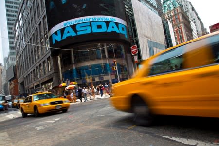 FILE PHOTO: Taxi cabs drive past the Nasdaq MarketSite in New York's Times Square