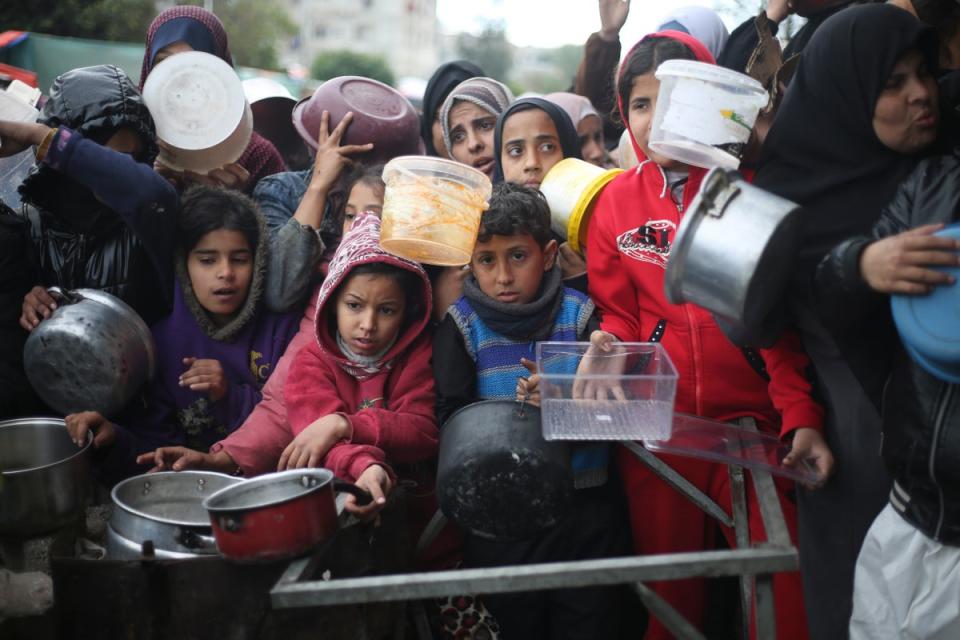 Palestinians line up for free food distribution during the ongoing Israeli air and ground offensive in Khan Younis, Gaza Strip, Friday, Feb. 2, 2024. (AP Photo/Hatem Ali)