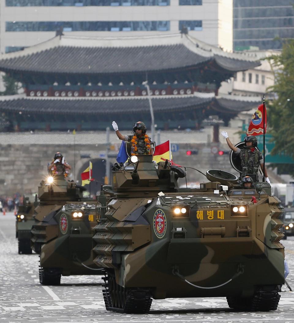 A South Korean soldier travelling in an amphibious vehicle, waves to the crowd during a parade to mark the 65th anniversary of Korea Armed Forces Day, in front of Sungnyemun Gate in central Seoul October 1, 2013. (REUTERS/Kim Hong-Ji)