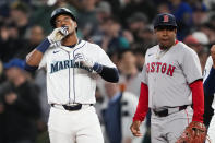 Seattle Mariners' Jorge Polanco, left, reacts to hitting a single, next to Boston Red Sox second baseman Enmanuel Valdez during the first inning of an opening-day baseball game Thursday, March 28, 2024, in Seattle. (AP Photo/Lindsey Wasson)