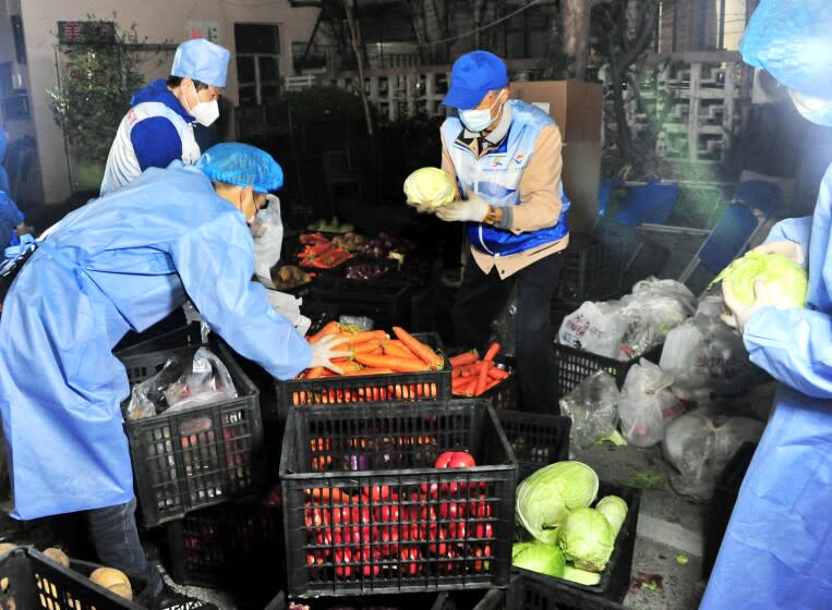 SHANGHAI, CHINA - APRIL 07: Volunteers arrange food supplies at a gated community after Shanghai imposed a citywide lockdown to halt the spread of COVID-19 epidemic on April 7, 2022 in Shanghai, China. (Photo by Yang Jianzheng/VCG via Getty Images)