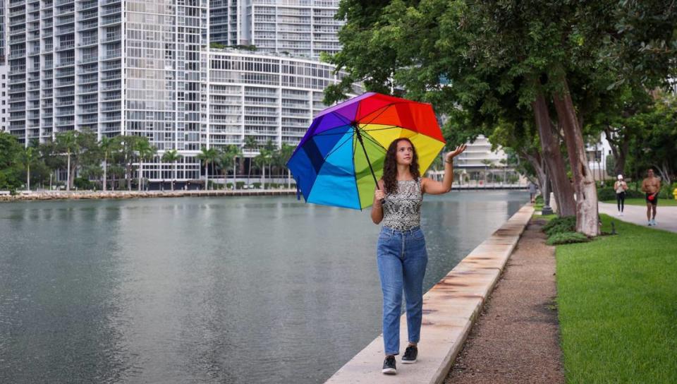 Elissa Teles Muñoz, 24, of the Climate Mental Health Network, is helping others cope with climate change anxiety by conducting research on its implications and impact on young Miami-Dade residents due to flooding and hurricanes. Muñoz walks along the waterway where luxury condo developments have boomed in the Brickell area on Tuesday, July 30, 2024.