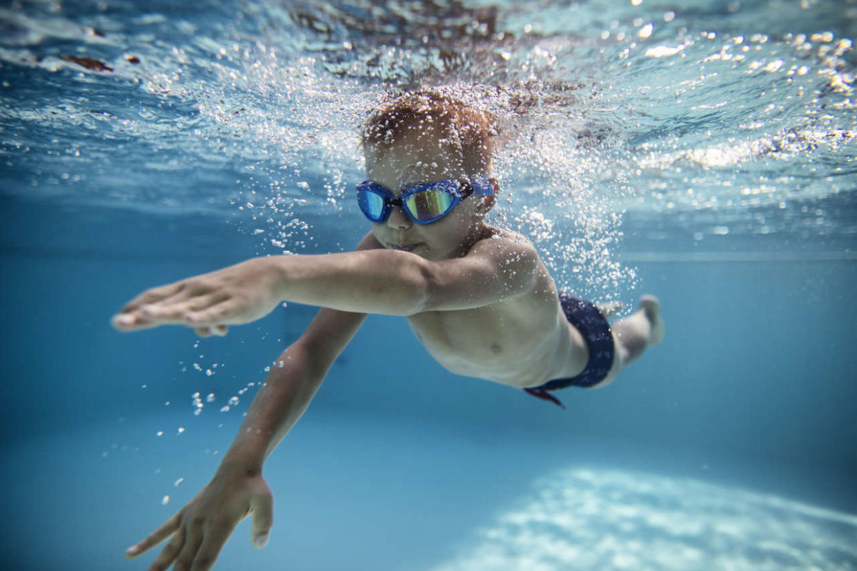 Portrait of little boy swimming underwater in the pool. Sunny summer day.
Nikon D850