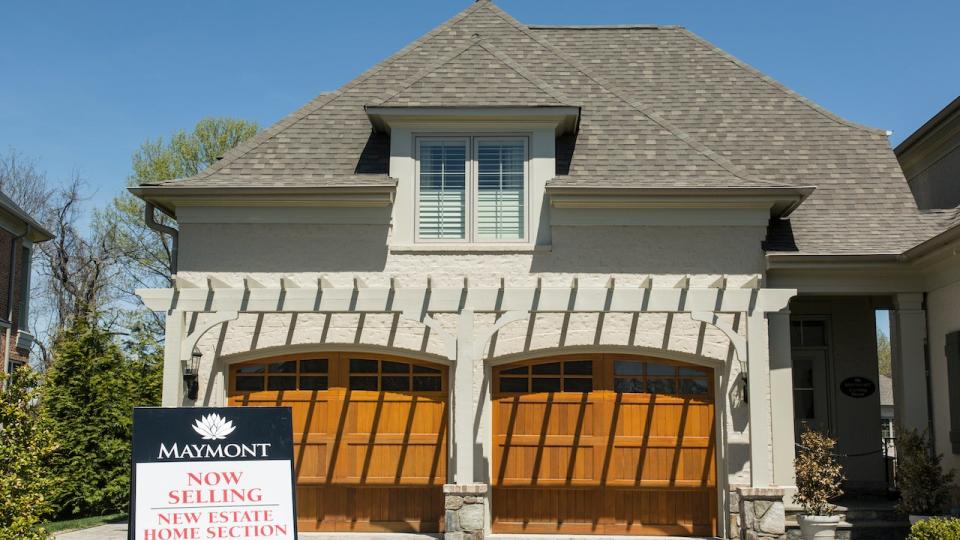 is the housing market about to crash? - the two-car garage and front door of a suburban home, with a maymont 