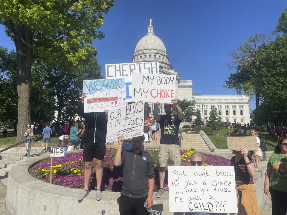 Protesters outside the Madison state Capitol hold signs saying: My Body My Choice, Our Blood Is on Your Hands, Alito, Thomas, Kavanaugh, Coney-Barrett, Gorsuch,  Roberts; You don't trust Me With a Choice ......But you trust me with a CHILD???