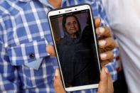 Shahid Ahmed, 45, holds his mobile phone displaying photo of his mother Irshad Begum, 72, who was killed in a plane crash, in Karachi
