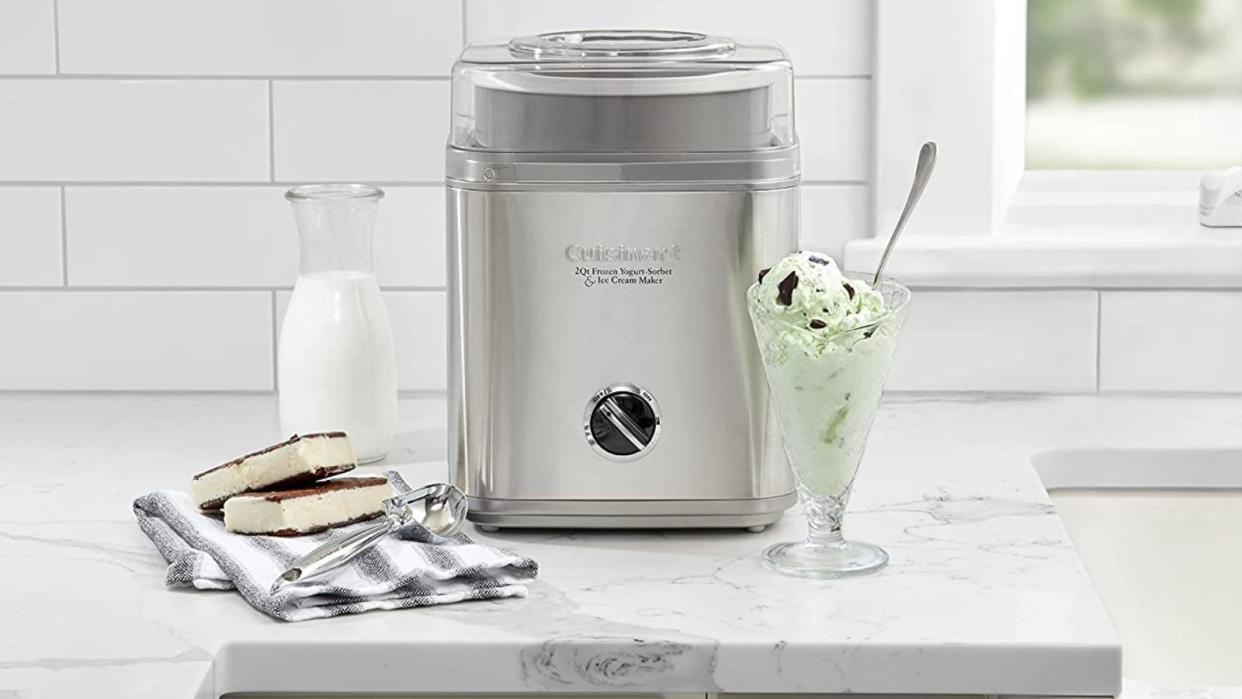  Cuisinart Ice Cream Maker on a marble countertop with ice cream and ice cream sandwiches around it 