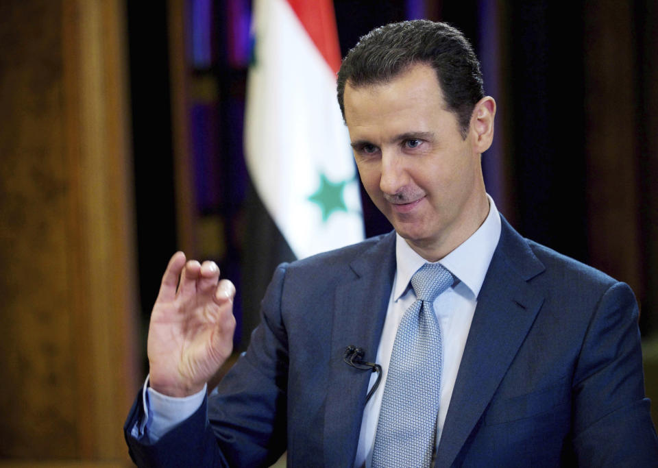 FILE - In this Feb. 10, 2015, file photo released by the Syrian official news agency SANA, Syrian President Bashar Assad gestures during an interview in Damascus, Syria. In Syria nowadays, there is an impending fear that all doors are closing. After nearly a decade of war, the country is crumbling under the weight of years-long western sanctions, government corruption and infighting, a pandemic and an economic downslide made worse by the financial crisis in Lebanon, Syria's main link with the outside world. (SANA via AP, File)