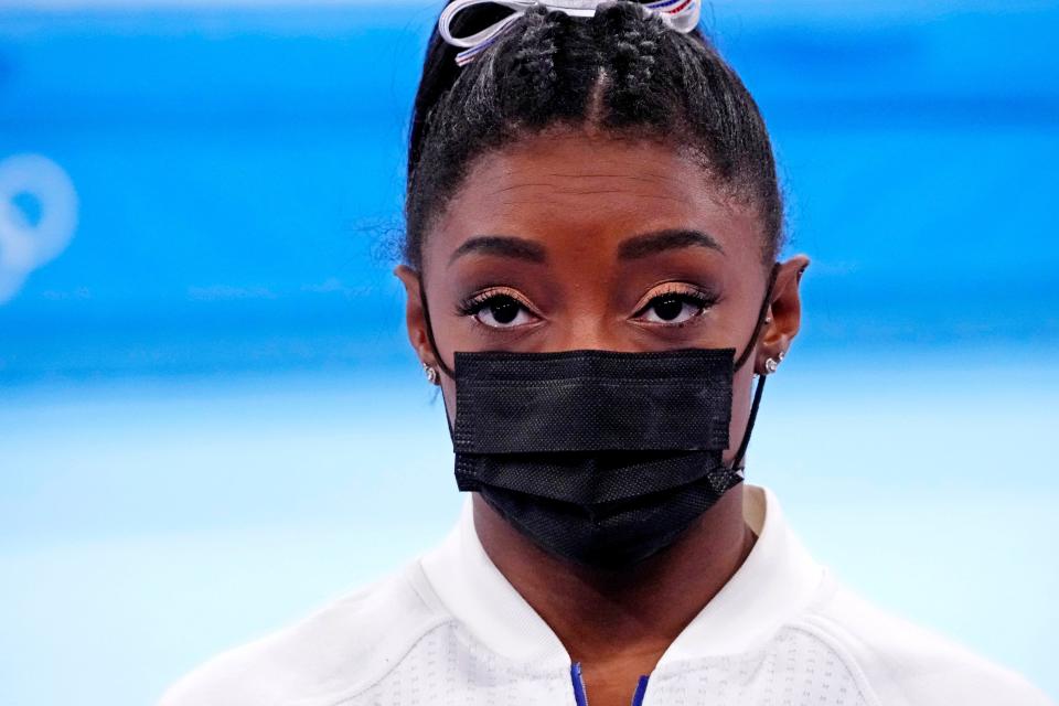 Simone Biles looks on after pulling out of the women's gymnastic team final.