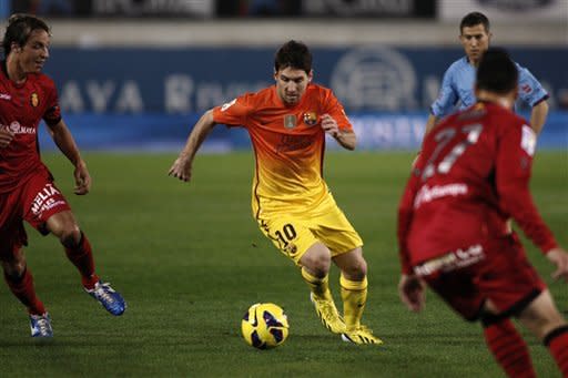 FC Barcelona's Lionel Messi from Argentina drives the ball next to RCD Mallorca's Joaqun Navarro Ximo, right, and Toms Pina, left, during a Spanish La Liga soccer match in Mallorca, Spain, Sunday, Nov. 11, 2012. (AP Photo/Tolo Ramon)