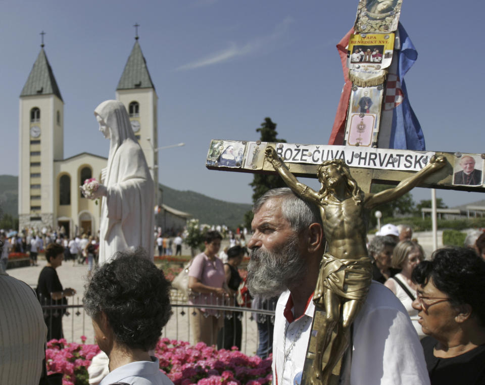 Pilgrims walk around a statue of the Blessed Virgin Mary near the church of St. James in Medjugorje, Bosnia and Herzegovina, some 120 kilometers (75 miles) south of the Bosnian capital of Sarajevo on Sunday, June 25, 2006. On Friday, May 17, 2024, the Vatican will issue revised norms for discerning apparitions "and other supernatural phenomena," updating a set of guidelines first issued in 1978. (AP Photo/Amel Emric, File)