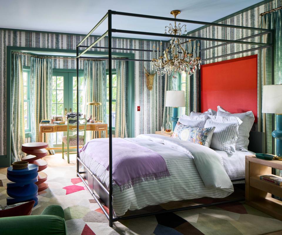 Bedroom with green walls and red headboard on double bed