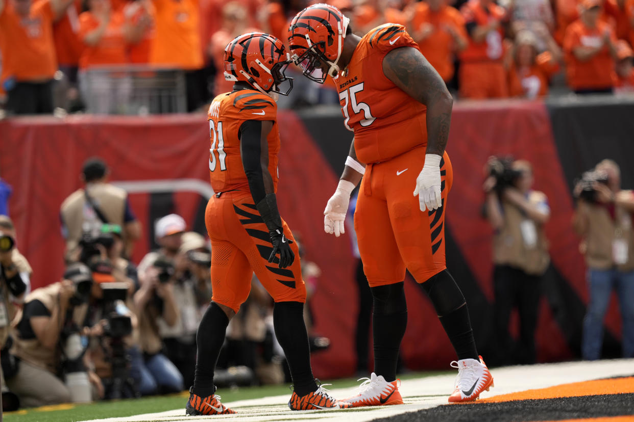 Cincinnati Bengals running back Zack Moss (31) celebrates with teammate Orlando Brown Jr. (75) after scoring on a 5-yard touchdown run during the second half of an NFL football game against the New England Patriots, Sunday, Sept. 8, 2024, in Cincinnati. (AP Photo/Carolyn Kaster)