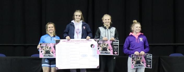 Clear Creek Amana's 120-pound senior Emma Descourouez (far left) standing on the podium after coming in third place.