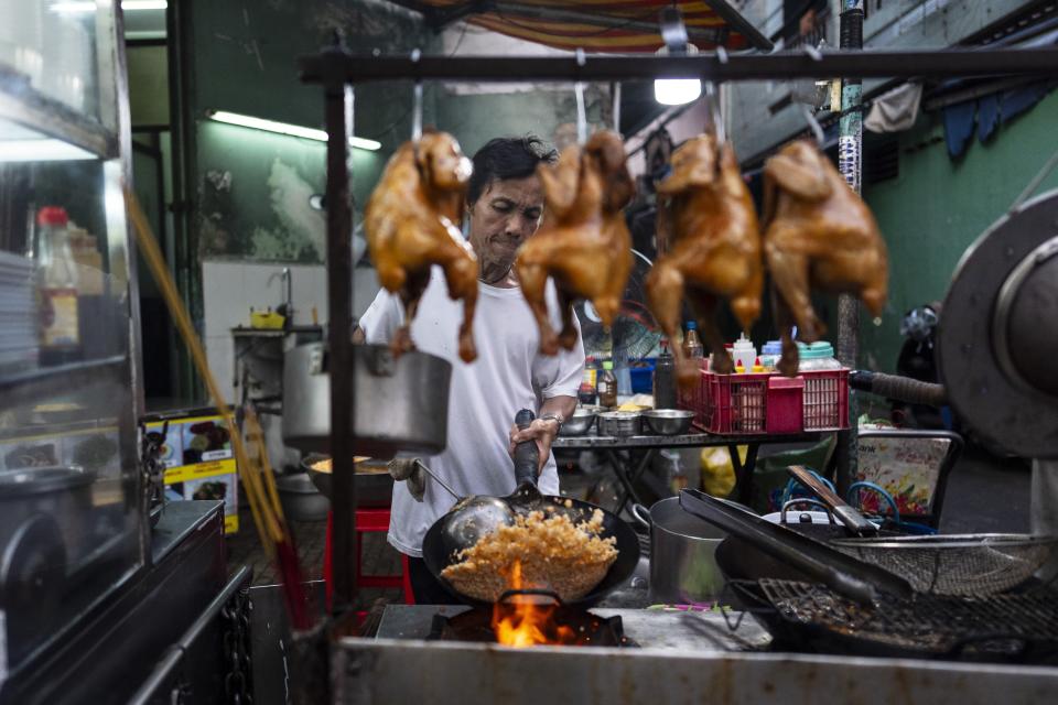 Restaurant owner Hien Ky prepares fried rice in Ho Chi Minh City, Vietnam, Saturday, Jan. 27, 2024. Vietnam is the world's third largest rice exporter, and the staple importance to Vietnamese culture is palpable in the Mekong Delta. (AP Photo/Jae C. Hong)