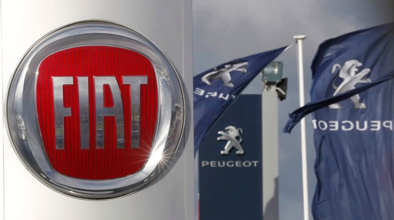 FILE PHOTO: The logos of car manufacturers Fiat and Peugeot are seen in front of dealerships of the companies in Saint-Nazaire