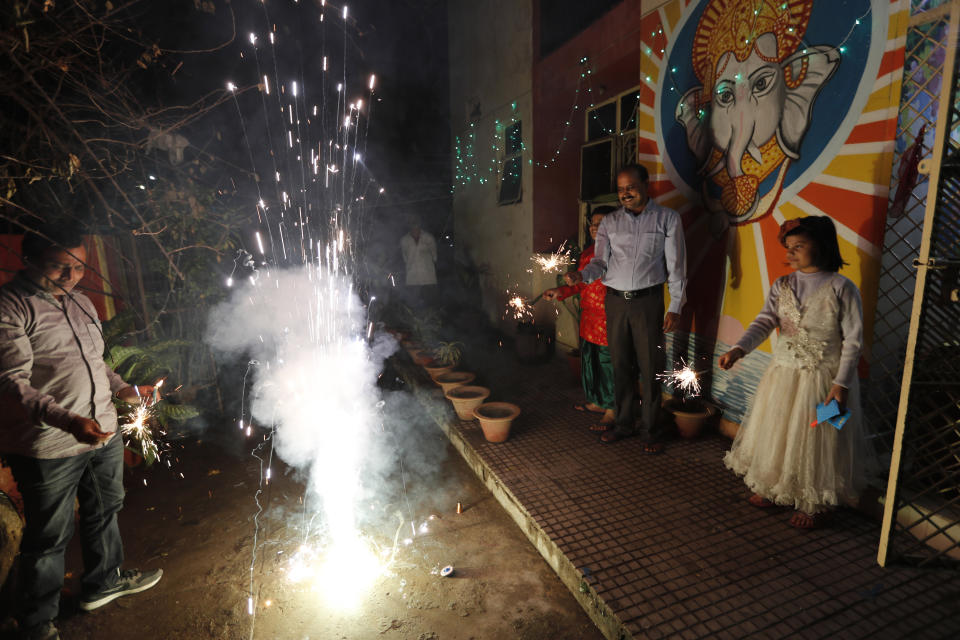 People play with fireworks during Diwali, the Hindu festival of lights, in Prayagraj, India, Saturday, Nov. 14, 2020. Hindus across the country are celebrating Diwali where people decorate their homes with lights and burst fireworks. (AP Photo/Rajesh Kumar Singh)