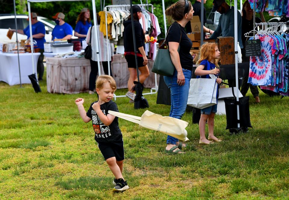 Thomas Gelcich, 4, of Westborough, spins around an empty shopping bag as his mother, Janet, and sister, Evie, 6, browse during the Grafton Farmers Market. Summer market hours are 2 p.m. to 6 p.m. every Wednesday at the Grafton Municipal Town Building on 30 Providence Road.