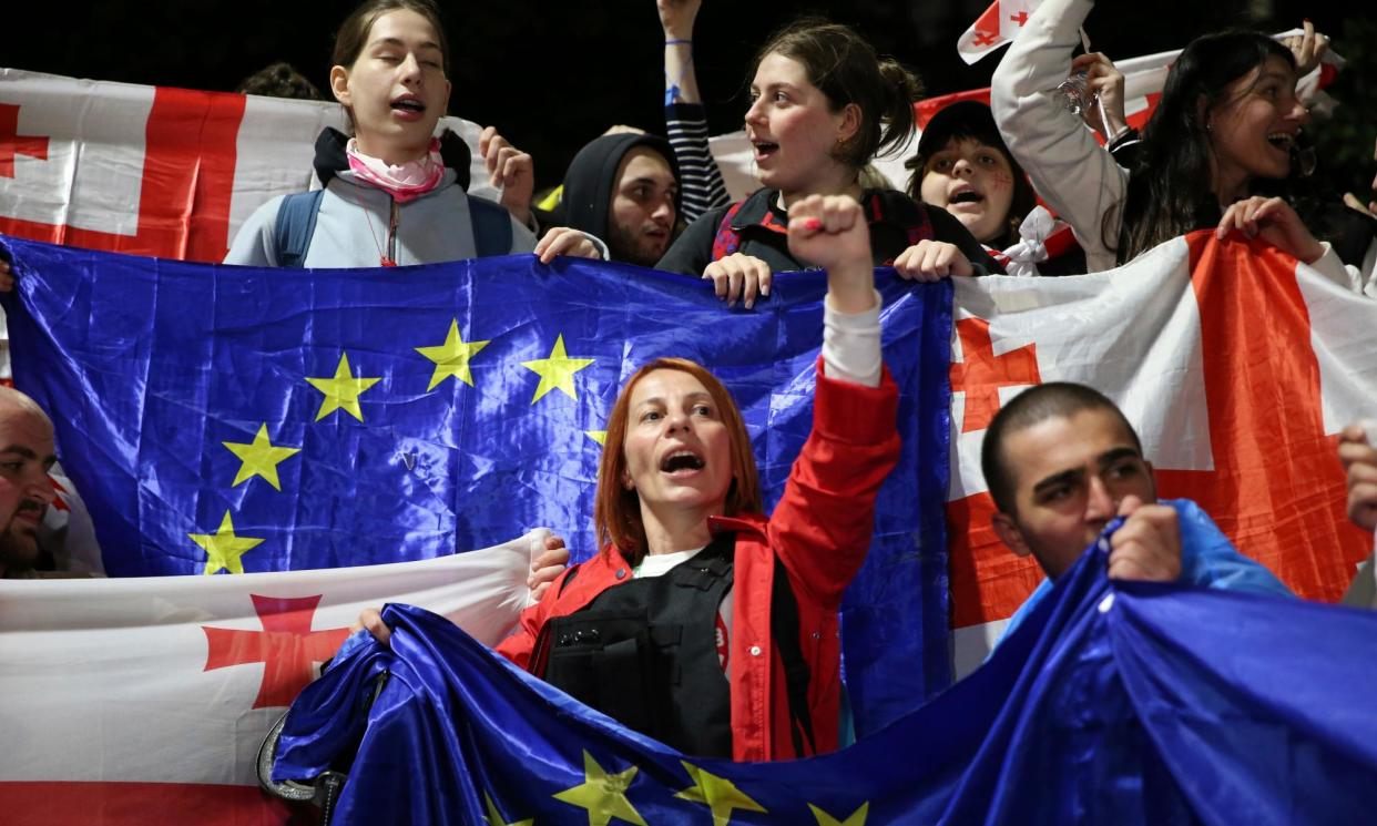 <span>Demonstrators with Georgian national and EU flags shout anti-government slogans near the parliament building in the centre of Tbilisi.</span><span>Photograph: Zurab Tsertsvadze/AP</span>