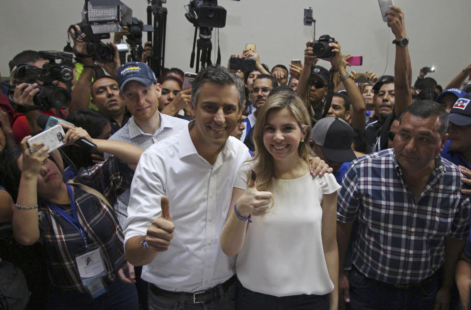 Presidential candidate for the Alianza Republicana Nacionalista party (ARENA), Carlos Calleja, and his wife Andrea give a thumbs up to the press, showing their thumbs are inked which means they voted, during the presidential election in San Salvador, El Salvador, Feb. 3, 2019. Salvadorans are choosing from among a handful of presidential candidates all promising to end corruption, stamp out gang violence and create more jobs in the Central American nation. (AP Photo/Salvador Melendez)