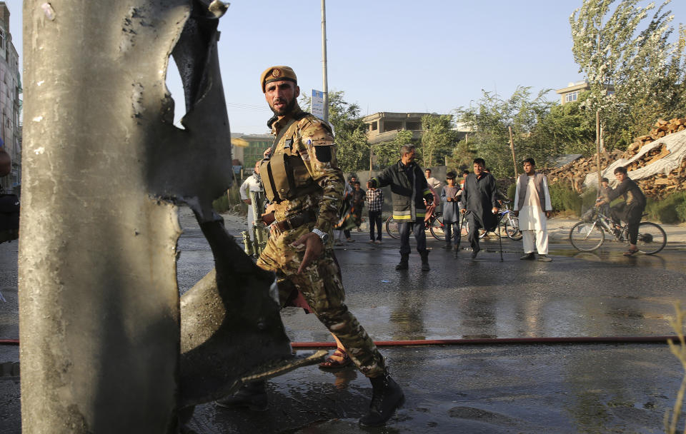 An Afghan police officer stands guard near the site of a deadly explosion in Kabul, Afghanistan, Tuesday, Aug. 6, 2019. A magnetic bomb was placed on a van carrying employees of the Interior Ministry's counter-narcotics division. In Kabul on Tuesday, a bomb targeted a van carrying employees of the Interior Ministry's counter-narcotics division. The blast killed five people and wounded another seven, Interior Ministry spokesman Nasrat Rahimi said. No one immediately claimed responsibility for the attack. (AP Photo/Rafiq Maqbool)