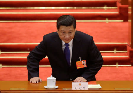 FILE PHOTO: China's newly elected President Xi Jinping takes a seat before the fifth plenary meeting of the National People's Congress (NPC) at the Great Hall of the People in Beijing, March 15, 2013. REUTERS/Jason Lee/File Photo