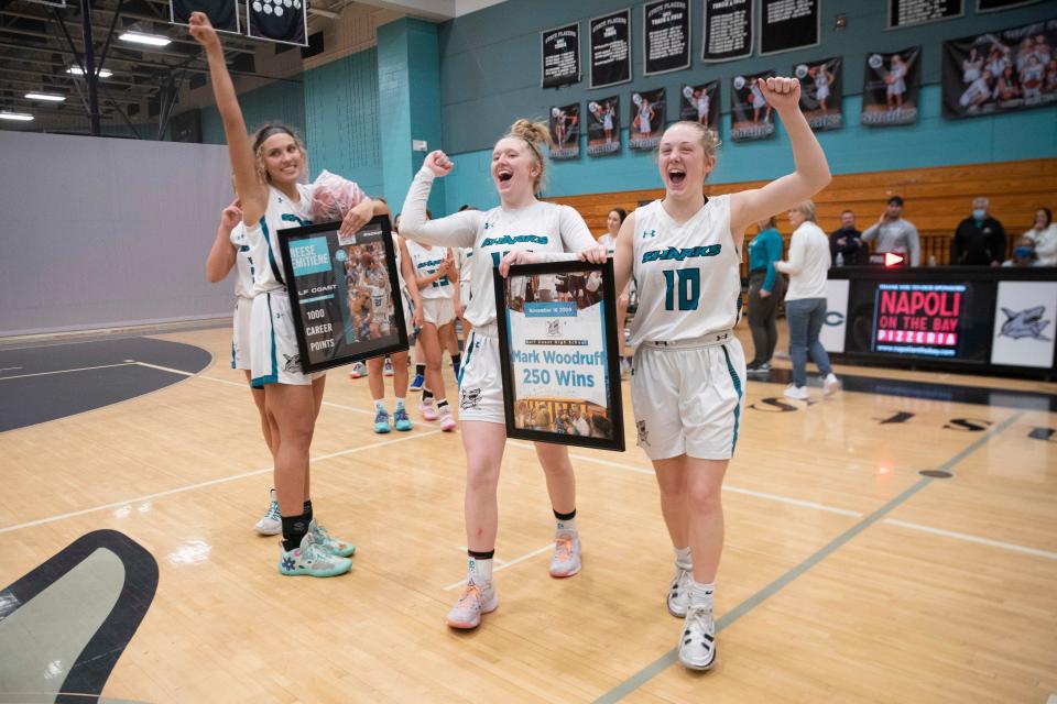 Gulf Coast players bring Gulf Coast's head coach Mark Woodruff a frame honoring 250 wins after defeating Seacrest Country Day 71-31, Saturday, Jan. 15, 2022, at Gulf Coast High School in Naples, Fla.Gulf Coast defeated Seacrest Country Day 71-31.