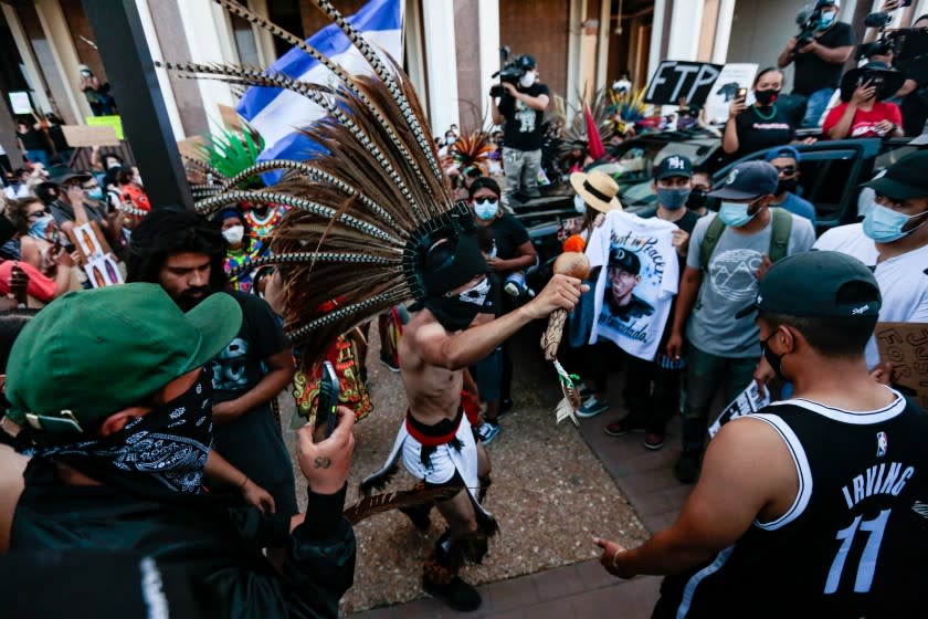 GARDENA, CALIFORNIA - JUNE 21: Native American dancers along with hundreds of people rallied and marched outside the Compton Sheriffs' Office in protest for the shooting of Andres Guardado, security guard who was fatally shot by a Los Angeles County sheriff's deputy on Sunday, June 21, 2020 in Gardena, California. (Jason Armond / Los Angeles Times)