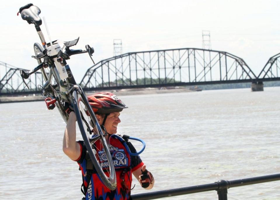 Emmanuel Scigliano of Storrs, Conn., hoists his bike after arriving in Davenport to complete RAGBRAI XXXIX.