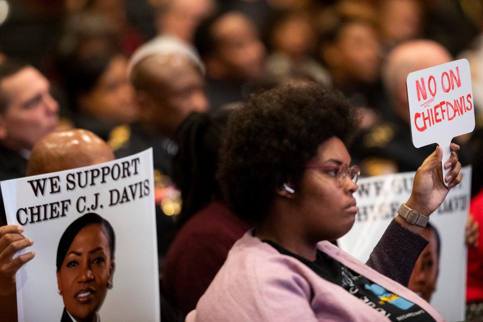 Supporters for Memphis Police Chief Cerelyn “C.J.” Davis hold up signs for her as Memphis activist Amber Sherman holds up a sign opposing her reappointment during Davis’ reappointment proceedings in the city council committee meeting at city hall in Memphis, Tenn., on Tuesday, January 9, 2024.