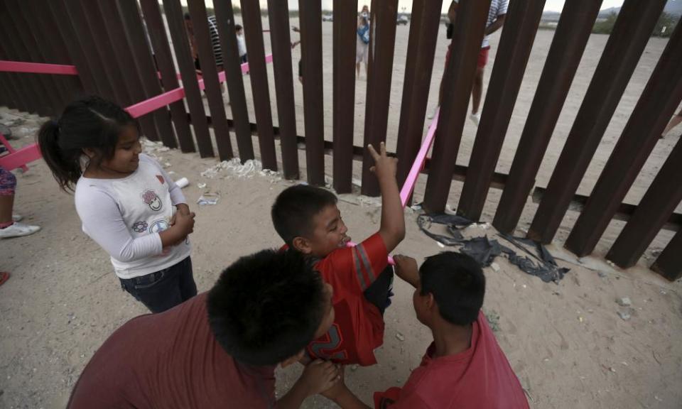 Children on the Mexican side play on the seesaw