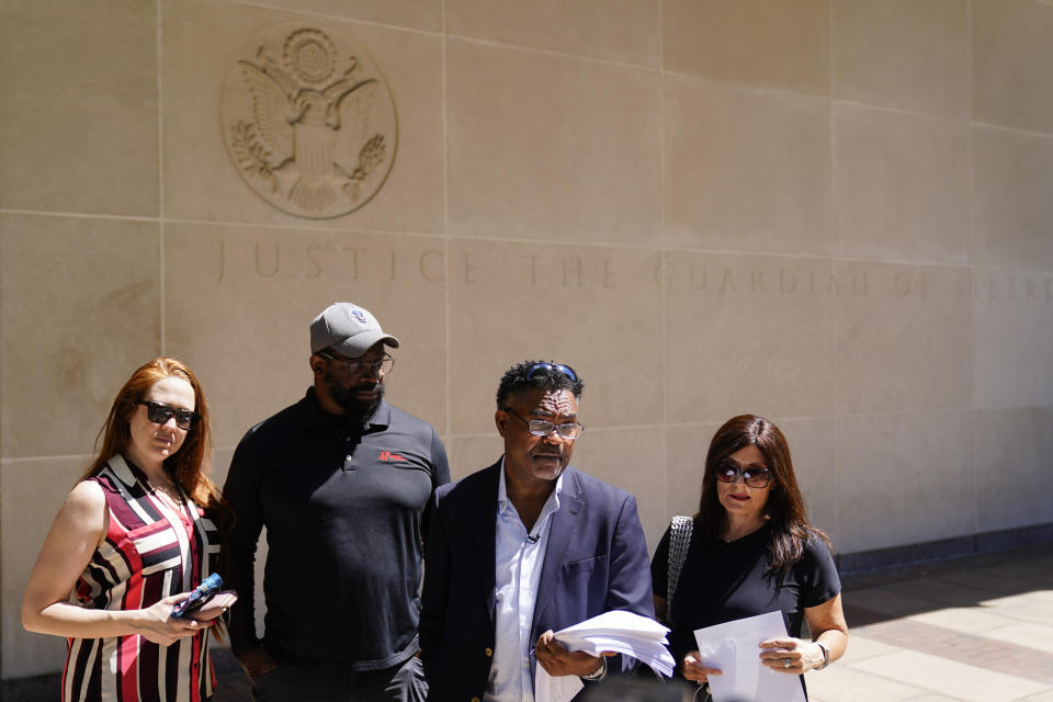 From the left, Brooke Vaughn, her husband former NFL player Clarence Vaughn III, former NFL player Ken Jenkins and his wife Amy Lewis read a letter before delivering tens of thousands of petitions demanding equal treatment for everyone involved in the settlement of concussion claims against the NFL, to the federal courthouse in Philadelphia, Friday, May 14, 2021. Thousands of retired Black professional football players, their families and supporters are demanding an end to the controversial use of “race-norming” to determine which players are eligible for payouts in the NFL’s $1 billion settlement of brain injury claims, a system experts say is discriminatory. (AP Photo/Matt Rourke)