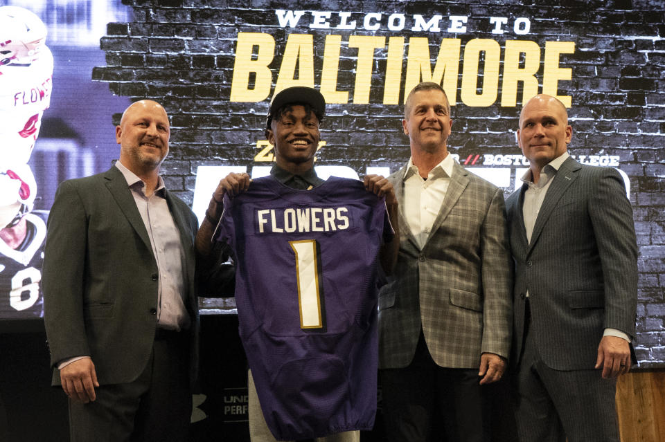 Baltimore Ravens first round draft pick Zay Flowers, second from left, holds a jersey while posing for photos with Ravens director of player personnel Joe Hortiz, head coach John Harbaugh and general manager Eric DeCosta during a news conference at the NFL football team's training center in Owings Mills, Md., Friday, April 28, 2023. (AP Photo/Julio Cortez)