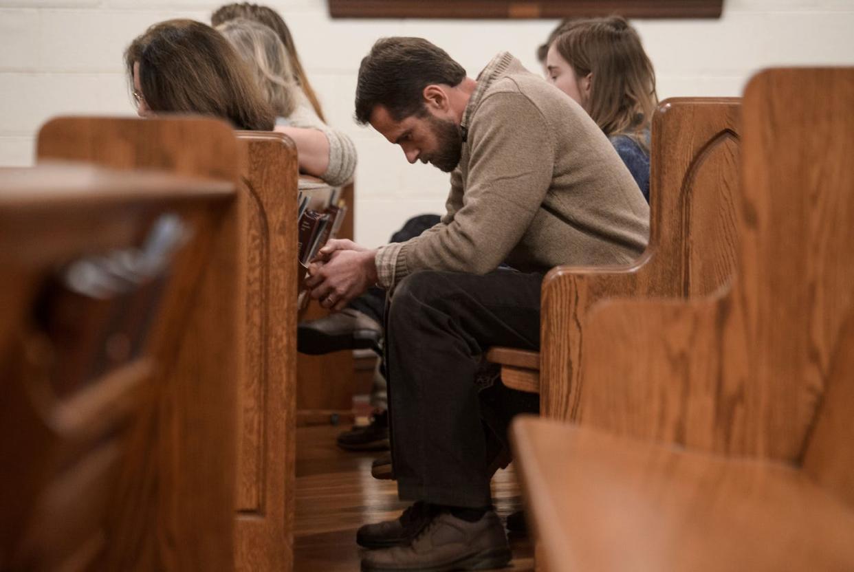 Young evangelical Christians are facing a dilemma whether to follow in the footsteps of their parents or pursue other choices. <a href="https://www.gettyimages.com/detail/news-photo/people-bow-their-heads-in-prayer-during-a-sunday-evening-news-photo/506230990?adppopup=true" rel="nofollow noopener" target="_blank" data-ylk="slk:Nicholas Kamm/AFP via Getty Images;elm:context_link;itc:0;sec:content-canvas" class="link ">Nicholas Kamm/AFP via Getty Images</a>