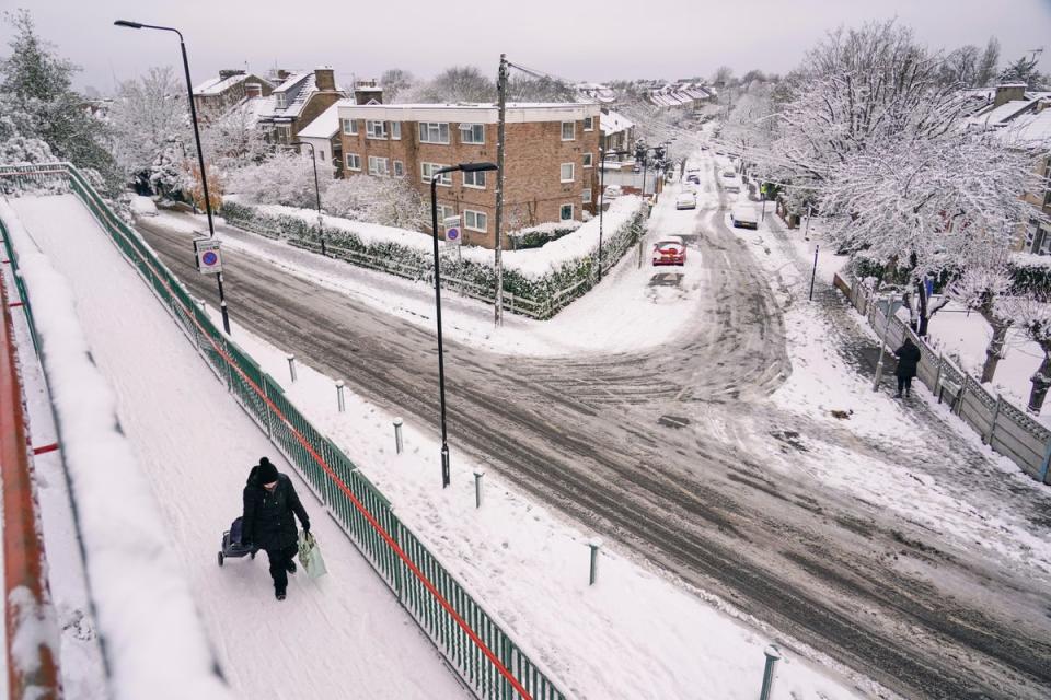 A woman pulls a trolley in Leytonstone on Monday morning (AP)