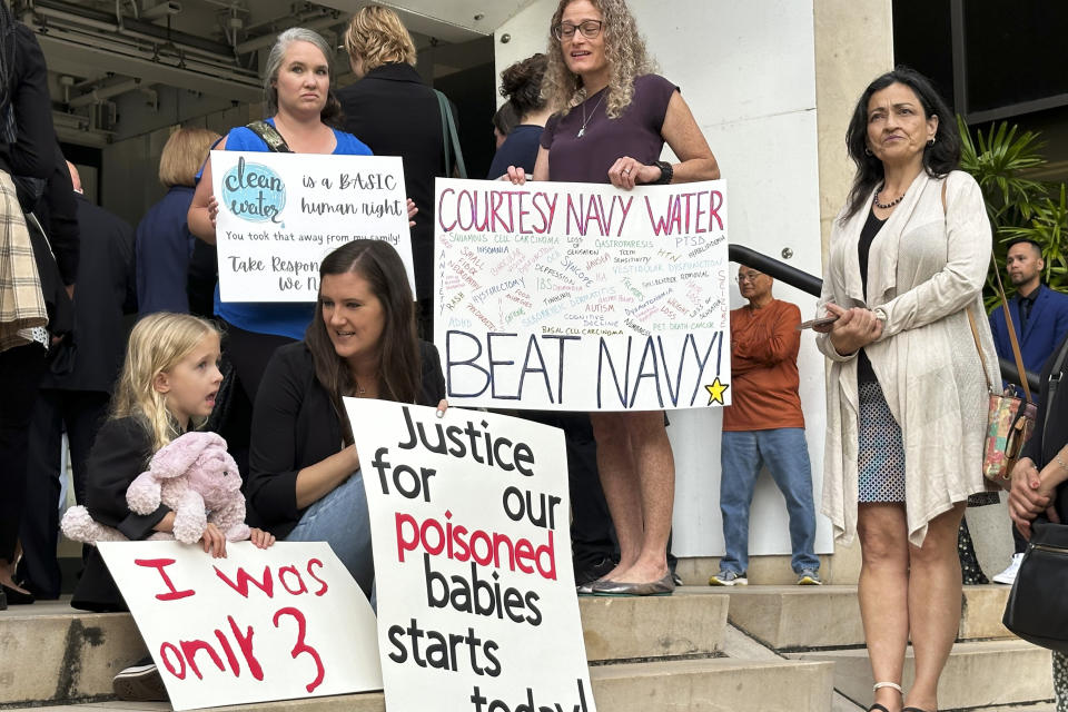 Plaintiffs in a trial for a mass environmental injury case hold signs outside the federal courthouse on Monday, April 29, 2024, in Honolulu. The trial is set to begin Monday more than two years after a U.S. military fuel tank facility under ground poisoned thousands of people when it leaked jet fuel into Pearl Harbor's drinking water. (AP Photo/Jennifer Kelleher)