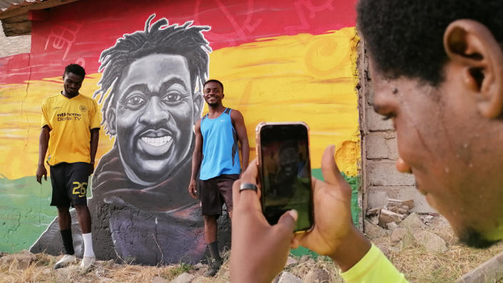 Football players pose in front of a Christian Atsu mural at Awudu Issaka Park, Tema, Ghana - Friday, February 24, 2023