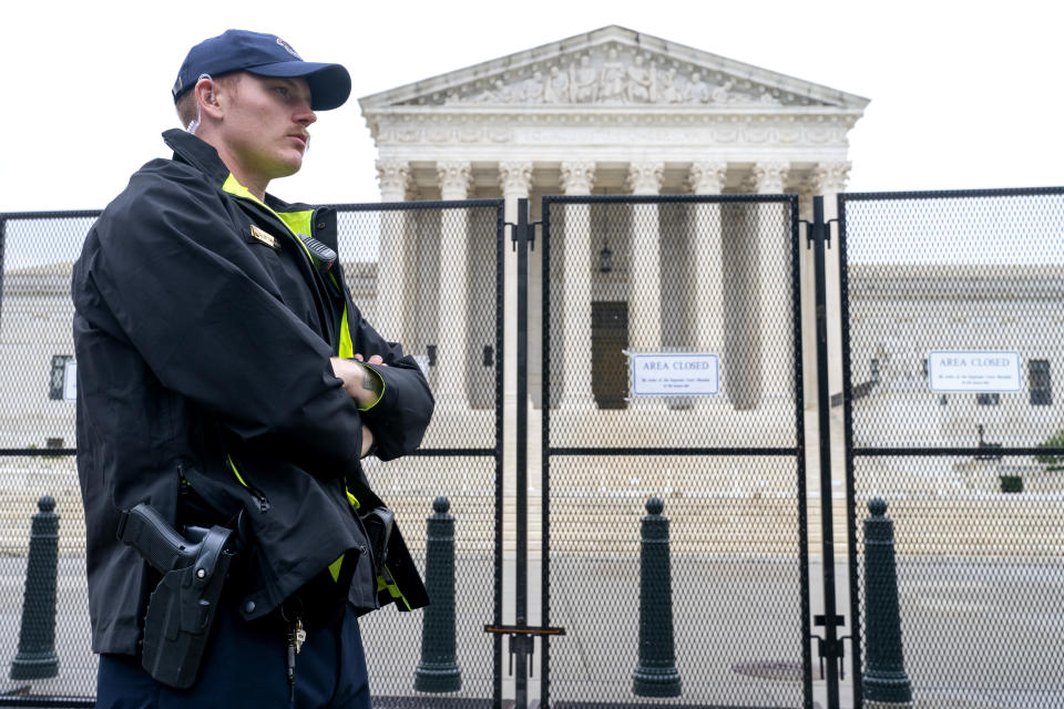 A Capitol Police Officer works by the anti-scaling fencing outside the Supreme Court, Thursday, June 23, 2022, in Washington. (AP Photo/Jacquelyn Martin)