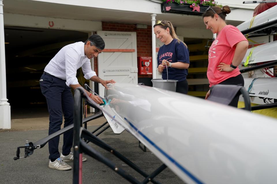 Prime Minister Rishi Sunak helps Leander Club members Shauna Fitzsimons (centre) and Harriet Taylor scrub down a boat during a visit to the Leander Club in Henley-on-Thames, Oxfordshire (Jonathan Brady/PA Wire)