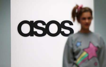 FILE PHOTO: A model walks on an in-house catwalk at the ASOS headquarters in London