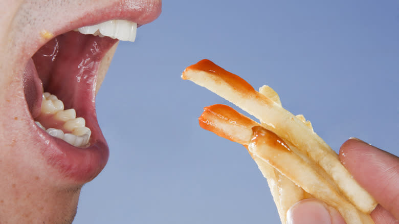 wide open mouth eating fries