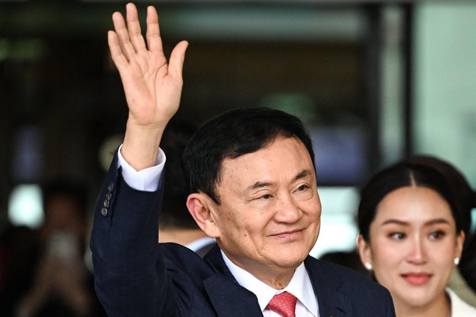 Thaksin Shinawatra greets supporters next to his daughter Paetongtarn Shinawatra after landing at Bangkok's Don Mueang airport on 22 August 2023 (AFP via Getty)