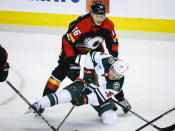 Minnesota Wild forward Mason Shaw, right, is checked by Calgary Flames defenseman Nikita Zadorov during the second period of an NHL hockey game Wednesday, Dec. 7, 2022, in Calgary, Alberta. (Jeff McIntosh/The Canadian Press via AP)